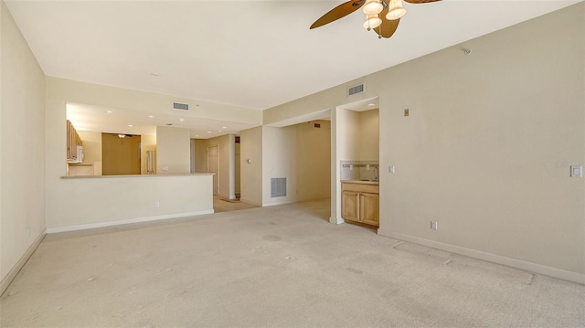 unfurnished room with ceiling fan and light carpet