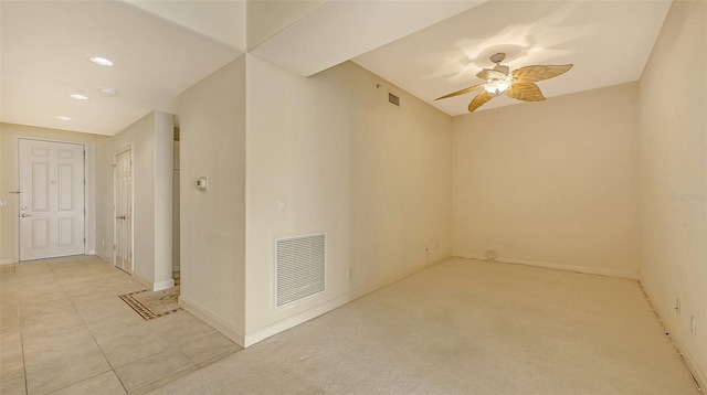 tiled spare room with ceiling fan