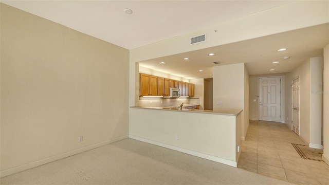 kitchen with light tile patterned floors and kitchen peninsula