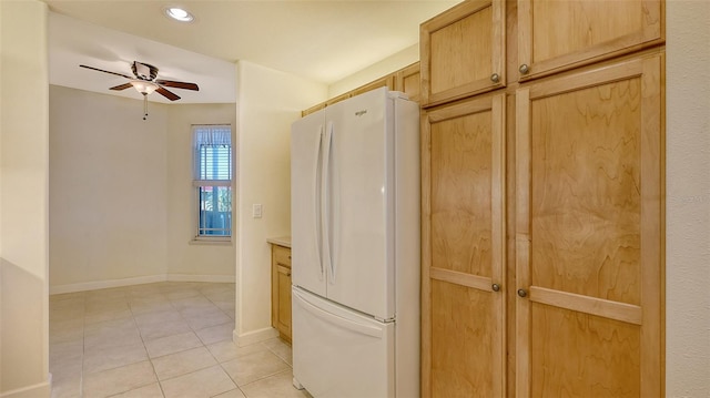 kitchen featuring light brown cabinetry, light tile patterned floors, ceiling fan, and white fridge