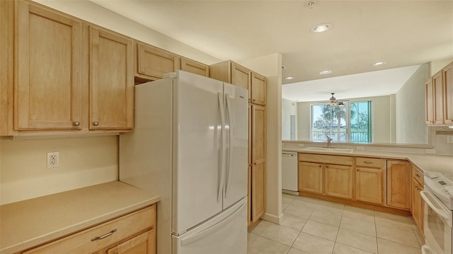 kitchen with light brown cabinetry, sink, light tile patterned floors, ceiling fan, and white appliances