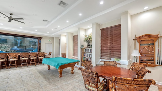 recreation room with light tile patterned floors, ceiling fan, a tray ceiling, pool table, and indoor bar