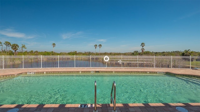 view of swimming pool featuring a water view