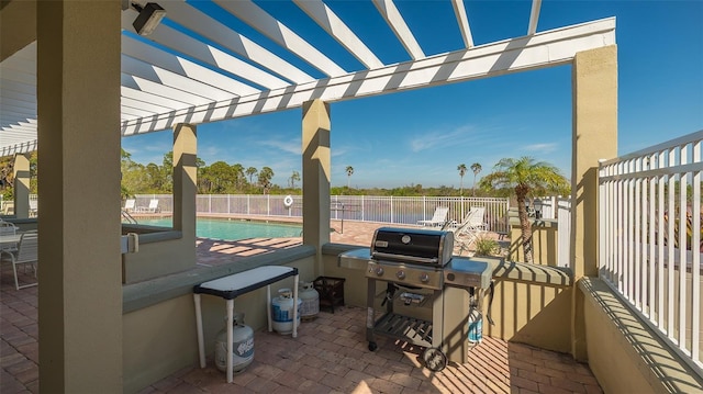 view of patio featuring a community pool, grilling area, and a pergola