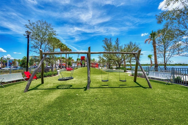 view of play area featuring a water view and a lawn