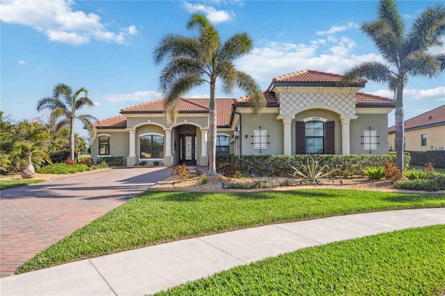 mediterranean / spanish home featuring a front lawn