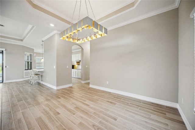 interior space featuring ornamental molding, light hardwood / wood-style floors, and a raised ceiling