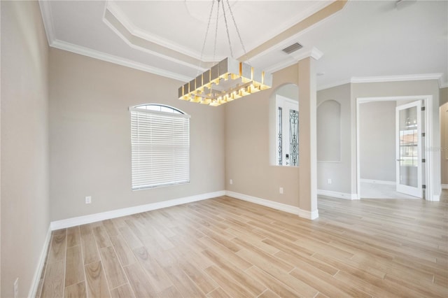 spare room featuring ornamental molding, light hardwood / wood-style floors, and a tray ceiling