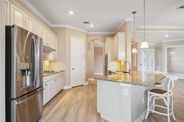 kitchen featuring sink, a kitchen breakfast bar, stainless steel refrigerator with ice dispenser, decorative light fixtures, and kitchen peninsula