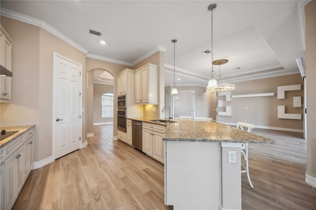 kitchen featuring sink, a breakfast bar, stainless steel appliances, light stone counters, and decorative light fixtures