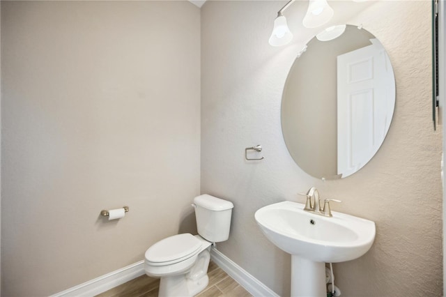 bathroom with hardwood / wood-style flooring, toilet, and sink