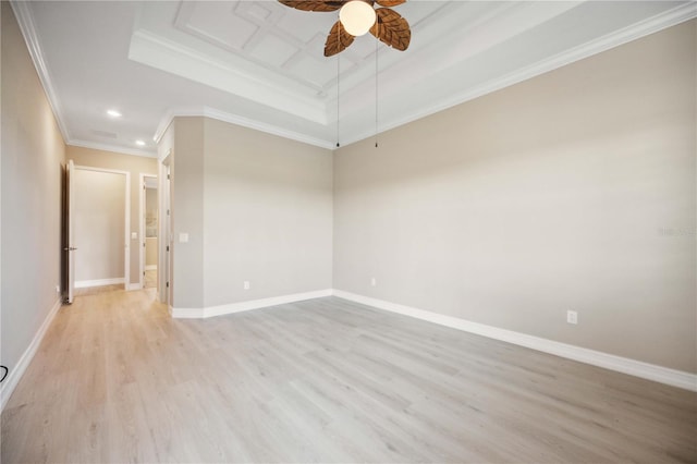 empty room with crown molding, a tray ceiling, ceiling fan, and light hardwood / wood-style flooring