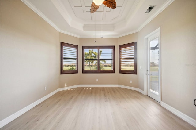 spare room with a tray ceiling, crown molding, ceiling fan, and light wood-type flooring