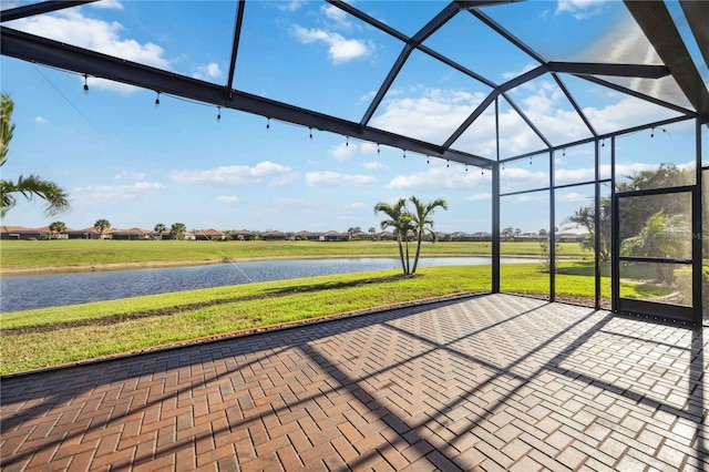 view of patio with a water view and a lanai