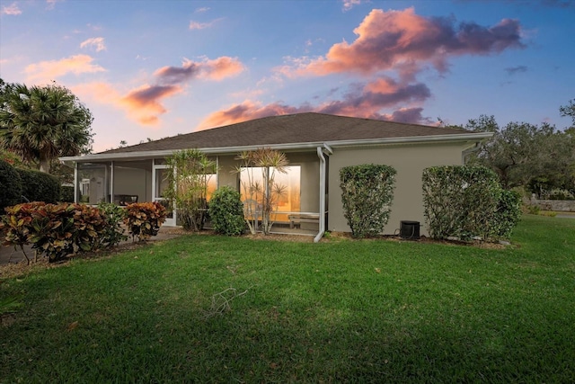 back house at dusk with a yard