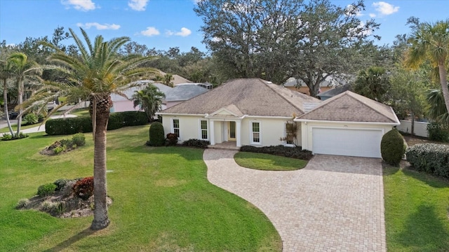 ranch-style house featuring a garage and a front lawn