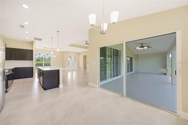 kitchen with ceiling fan with notable chandelier, a center island, and pendant lighting