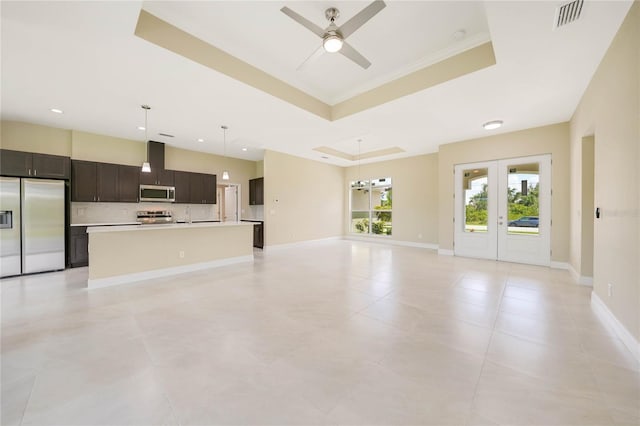 unfurnished living room featuring french doors, light tile patterned flooring, ceiling fan, and a tray ceiling