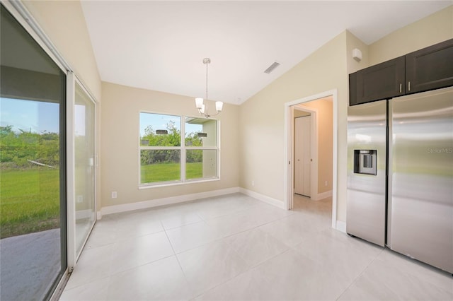 unfurnished dining area with a notable chandelier, light tile patterned floors, and vaulted ceiling