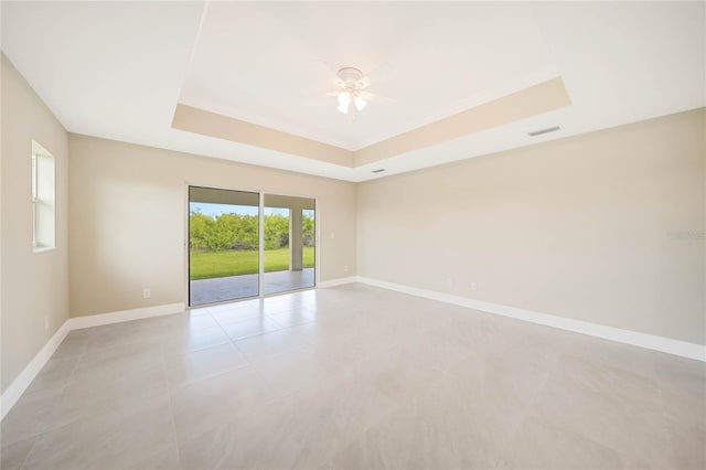 unfurnished room with ceiling fan, a raised ceiling, and light tile patterned floors