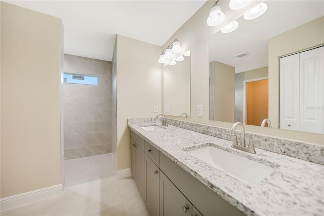 bathroom featuring vanity, tile patterned flooring, and a tile shower