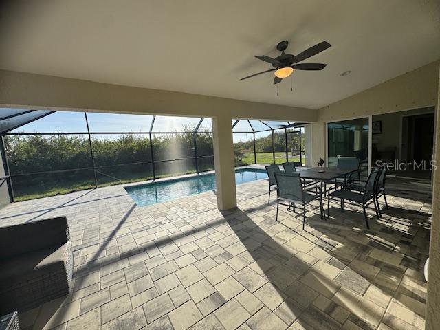 view of pool featuring a lanai, a patio area, and ceiling fan