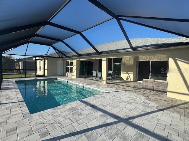 view of swimming pool with a lanai and a patio area