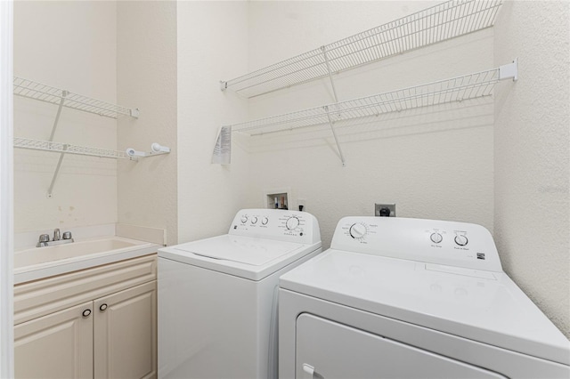 washroom featuring cabinets, washing machine and dryer, and sink