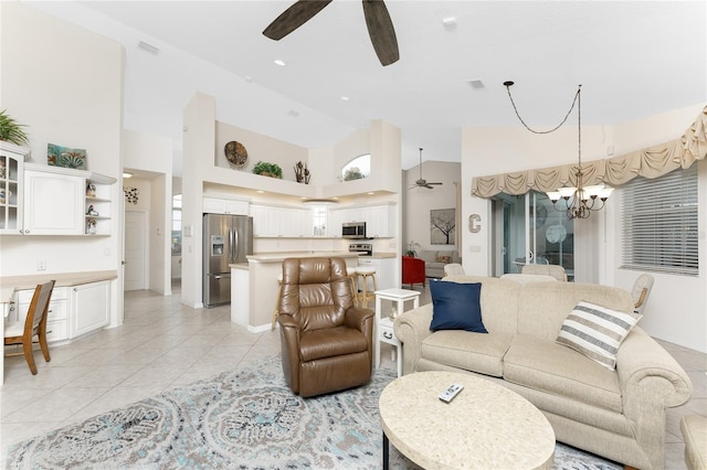 tiled living room featuring ceiling fan with notable chandelier and a high ceiling