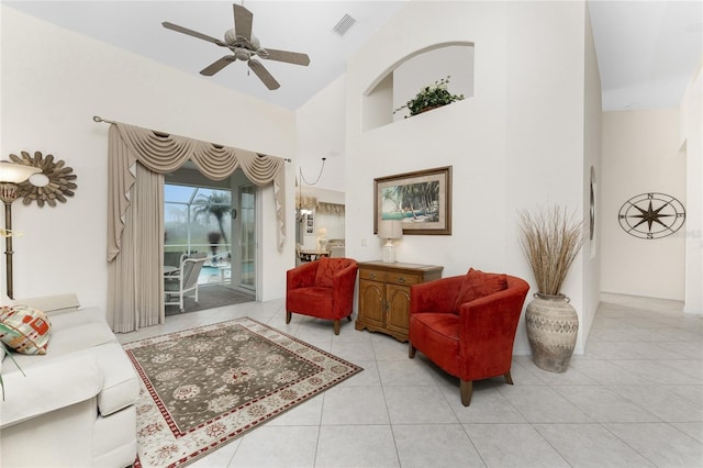 living room featuring light tile patterned floors, ceiling fan, and a high ceiling