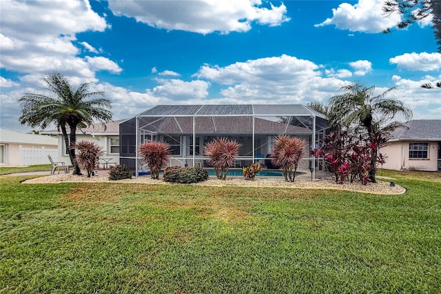 rear view of property with a lanai and a lawn