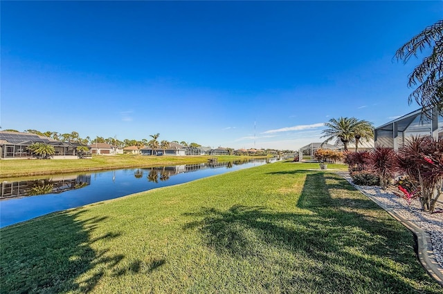 view of yard with a water view and a lanai