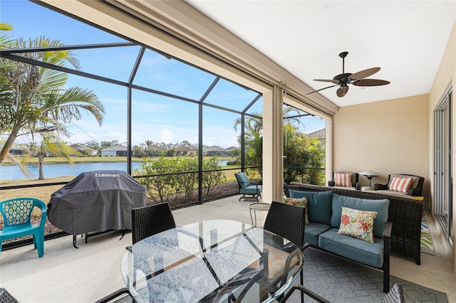 sunroom / solarium featuring a water view and ceiling fan