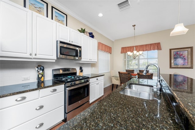 kitchen with white cabinetry, stainless steel appliances, sink, and hanging light fixtures