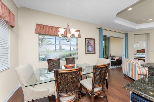 dining area featuring dark hardwood / wood-style flooring, a notable chandelier, and a raised ceiling