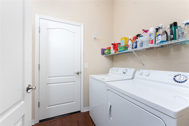 washroom with washing machine and clothes dryer and dark hardwood / wood-style floors