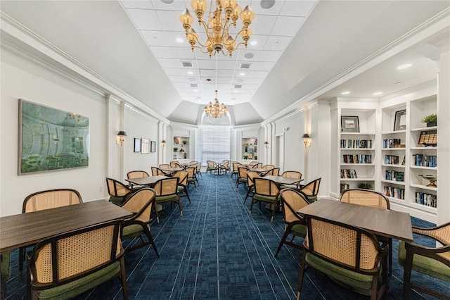 dining space with crown molding, carpet flooring, built in features, and a chandelier