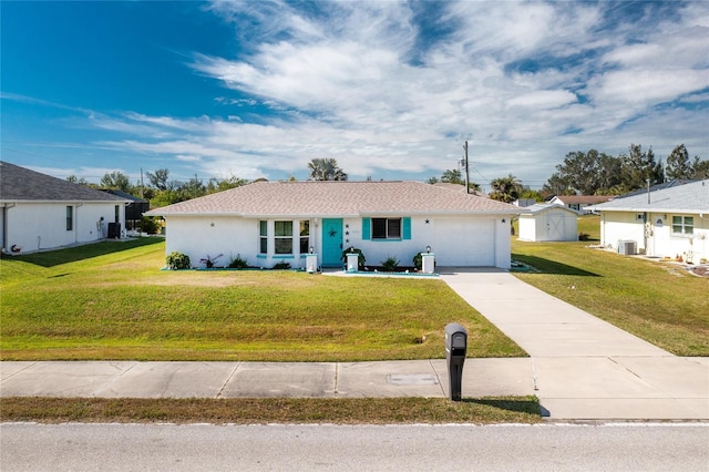 ranch-style home featuring cooling unit, a garage, and a front yard