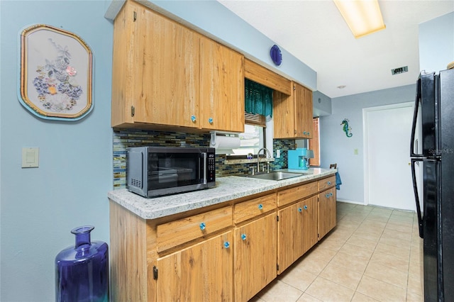 kitchen featuring black fridge, sink, decorative backsplash, and light tile patterned floors