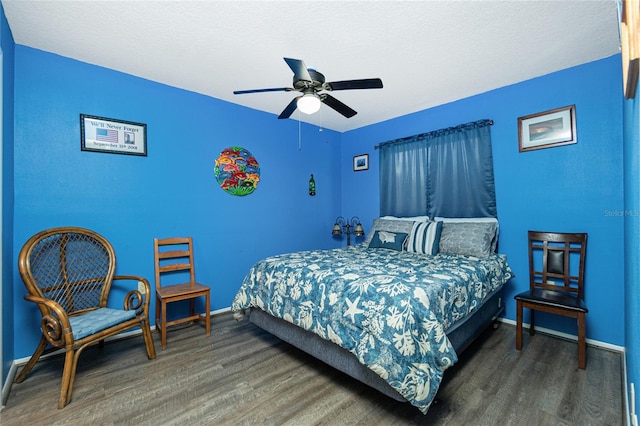 bedroom with a textured ceiling, dark wood-type flooring, and ceiling fan