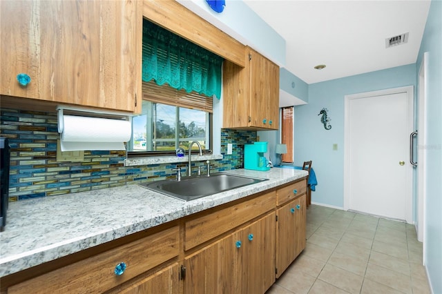 kitchen featuring light tile patterned flooring, sink, and backsplash