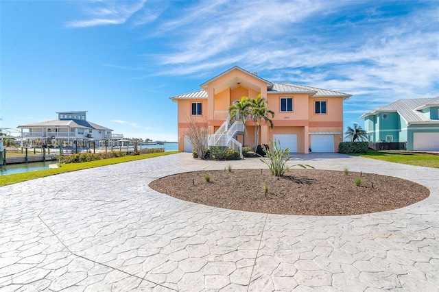 view of front of house with a garage and a water view