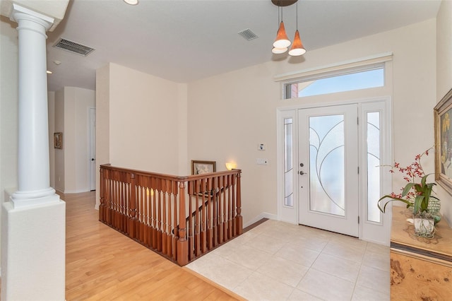 entryway featuring light hardwood / wood-style floors and ornate columns