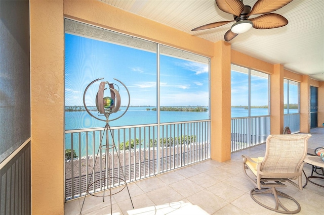 sunroom with a water view, ceiling fan, and plenty of natural light