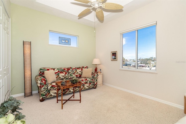 living area featuring light carpet and ceiling fan