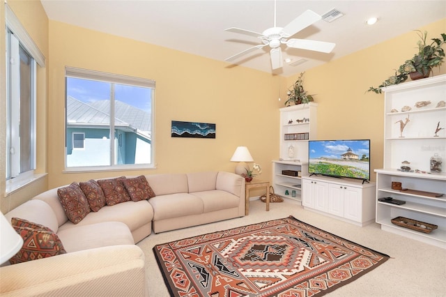 carpeted living room with ceiling fan