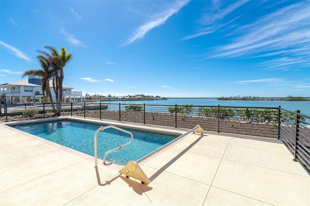 view of swimming pool with a patio and a water view