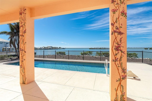 view of swimming pool featuring a patio and a water view