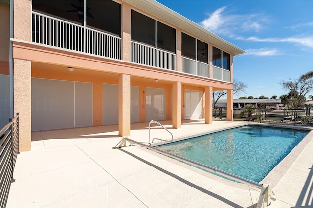 view of swimming pool with ceiling fan and a patio