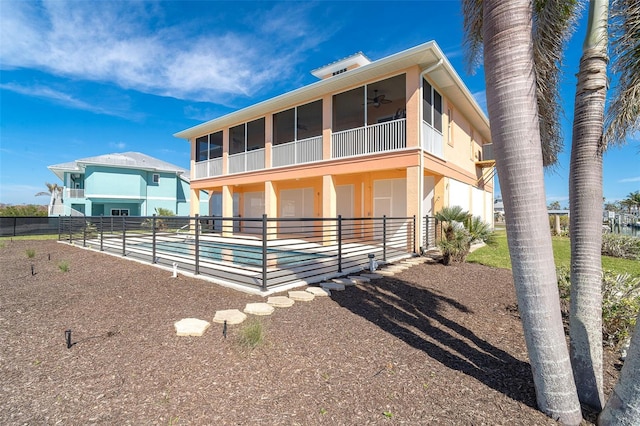 view of front of house with a pool, ceiling fan, and a sunroom